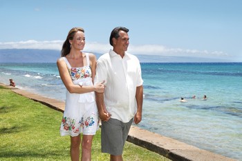 Picture of a couple walking along the ocean in front of the Aston Paki Maui condo rentals near the Kaanapali Beach Resort.